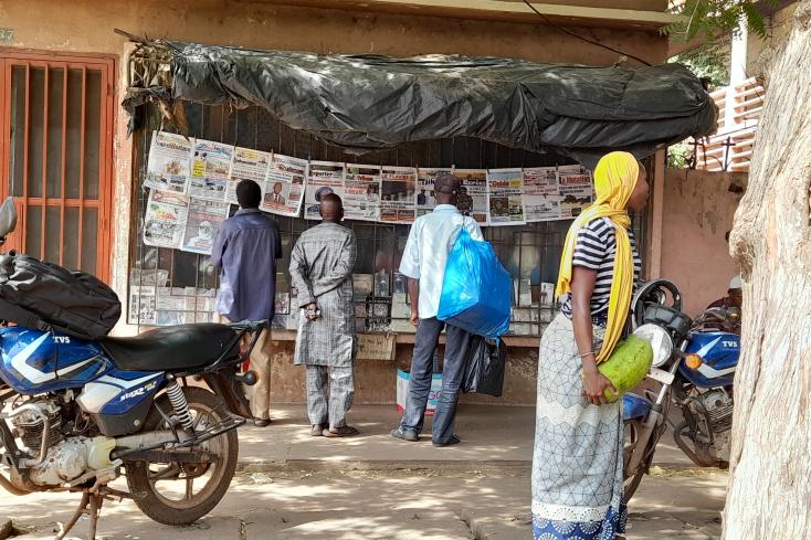 Passanten lesen die öffentlich aushängende Tageszeitung. Bamako, Mali. 2023. Foto: Helga Dickow